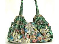 Designer Inspired Multi Color Snake Print PVC Handbag with big ring accents on the sides of the bag. Double handle with zipper closure & solid color gathered accents on the start of the straps.