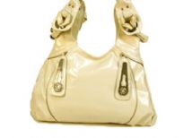 Designer Inspired Hobo Bag has metal accents and a double handle. Bag has a zipper closure. Made of PU (polyurethane).