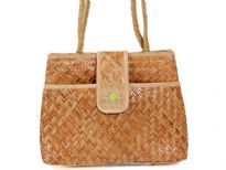 Straw and jute shoulder bag made with double shoulder straps and a front flap magnet closure. 