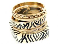 Tribal inspired design ivory wooden & metal bangle with black painted lines. 4 gold tone bangles with each having its own etched design or is plain & simple. Funky looking set can give an edge to any kind of outfit.