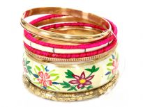 Multi colored floral print on ivory wide cuff bangle makes this 7 piece fashion bangles set unique & attractive. 5 thin bangles are in gold, fuchsia, ivory colors in different designs/material and also a gold bangle with etched design on it.