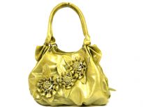 Fashion Handbag in Shining PVC Material with top zipper closure and double shoulder handle. Same color triple flower appliques in the front. Belt like accents on the sides of the bag.