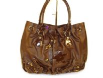 Designer Inspired Handbag with drawstring closure and a double handle has flowered applique details and ruches at bottom. Made of PU (polyurethane).