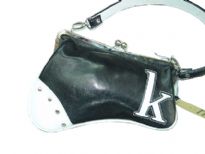 Asymmetric handbag has a detachable single strap, a framed kiss lock closure, and letter detail at corner. Made of faux leather.