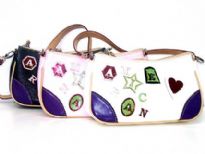 PVC Fashion Handbag has a single strap, a top zipper closure and embellished letters and shapes. Made of faux leather.