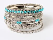 Beautifully hand crafted silver colored set of 8 fashion bangles in assorted widths & pattern. Each has its own metal pattern with one wide bangle having colored mirrors & also one thin bangle with colored mirrors. Expert craftsmanship reflects through this stylish set.