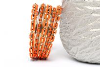 This Orange Beads Gold Metal Fashion Bangles Set can add zing to nay kind of outfit. Set includes 4 thin bangles, 2 petal patterned with beads and 3 bangles having beads in boxy shape. Durable & long lasting quality. 