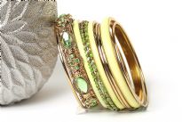 Chunky looking assortment of 10 pieces  including 4 thin bangles, 3 lime green resin bangles, 2 thin green bangles & one wide metal pattern bangle with green rhinestones on it. This set can light up any outfit. 