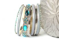 Chunky looking assortment of 10 pieces including 4 thin metal bangles, 3 periwinkle blue resin bangles, 2 thin  bangles with blue resin & one wide metal pattern bangle with turquoise rhinestones on it. This set can give funky look to any kind of outfit. 