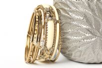 This Ivory with silver hand crafted fashion bangles set has 8 pieces - one broad resin bangle in mesh metal frame, one black resin bangle, 2 thin beaded bangles & 4 thin silver colored bangles. Matches with almost any kind of outfit & very durable.