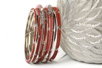 Elegant looking silver metal fashion bangles set of 12 pieces has small rust beads on 7 thin bangles, 3 thin silver bangles & 2 are resin bangles encrusted in silver metal frame. 