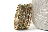 Gold colored Metal Fashion Bangles Set with Beads in Shades of Green. Bangles have a wavy pattern which is embellished with beads all around it. Sized to fit small to medium wrists.