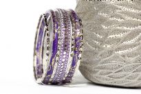 Shiny & Glittery seven piece set of fashion bangles in purple hues includes one wide bangle in Aluminium with mirrors design on it, 2 resin bangles with gold glitter inside them & 4 thin silver bangles. Hand crafted in India.