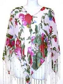 V-neck 100% rayon poncho top in white color with multi colored floral print. Hanging patterned fringes along its border. Imported.