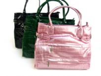 Croco Embossed shining patent leather spacious handbag with double handle, top zipper closure & belt like embellishments on the sides of the bag. Multiple zipper pockets in the front. Made of PU (polyurethane).