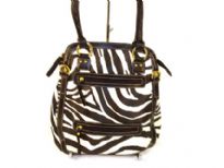 Designer Inspired Tote bag has a zebra print pattern and multiple zipper details. Bag has a top zipper closure and a short double handle. Made of faux leather.