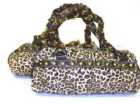 Round Shoulder Bag with animal print pattern has a double handle, top zipper closure and studded details. Made of PU (polyurethane)
