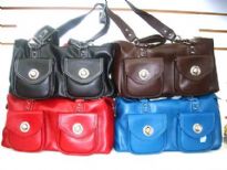 PVC Handbag has a top zipper closure and a double handle. Bag has outside pockets with twist lock closure.