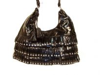 PVC fashion Hobo Handbag has studded details has a metallic texture, a top zipper closure, and a single strap. Made of faux leather.