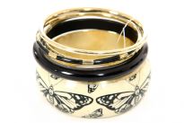 This exotic five pieces bangles set has one wide cuff butterfly print resin bangle, one thick & one thin black resin bangle and two gold colored metal bangles. Imported.