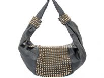 Faux Leather Studded Shoulder bag. This one piece bag has golden studs in the middle of the bag as well as on single shoulder strap. Top zipper closure.