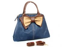 Bow accent dual compartment fashion handbag. Adjustable shoulder strap included. Back zipper pocket.