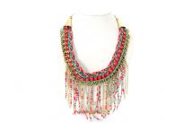 Links design gold tone brass necklace intertwined with multi color braided thread & studs like hot pink resins. Hanging chains & resins in multi colors gives a bib look to this statement necklace. Imported.