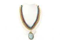 Two tone braided thread & metal gold tone links chain are intertwined to make this beautiful neck piece which also has a hanging oval pendant in resin. Small blue rhinestones decorate this necklace all over. 