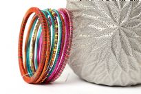Colorful & lightweight 12 pieces bangles set can be matched with any kind of outfit. 9 thin glittery bangles, one thin beaded bangle & 2 threaded bangles - one fuchsia/blue & one orange/multi colored. Hand crafted in India.   
