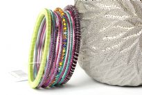 Colorful & lightweight 12 pieces bangles set can be matched with any kind of outfit. 9 thin glittery bangles, one thin beaded bangle & 2 threaded bangles - one lime green & one multi colored. Hand crafted in India.   
