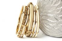 Beautiful Gold colored Metal Fashion Bangles Set can give that chic style to any kind of outfit at any time of the day. Set includes 3 thin gold bangles, 3 thin beaded bangles, 1 floral metal pattern bangle, 2 resin bangles in gold frame & one wide ivory resin bangle encrusted in gold frame. 